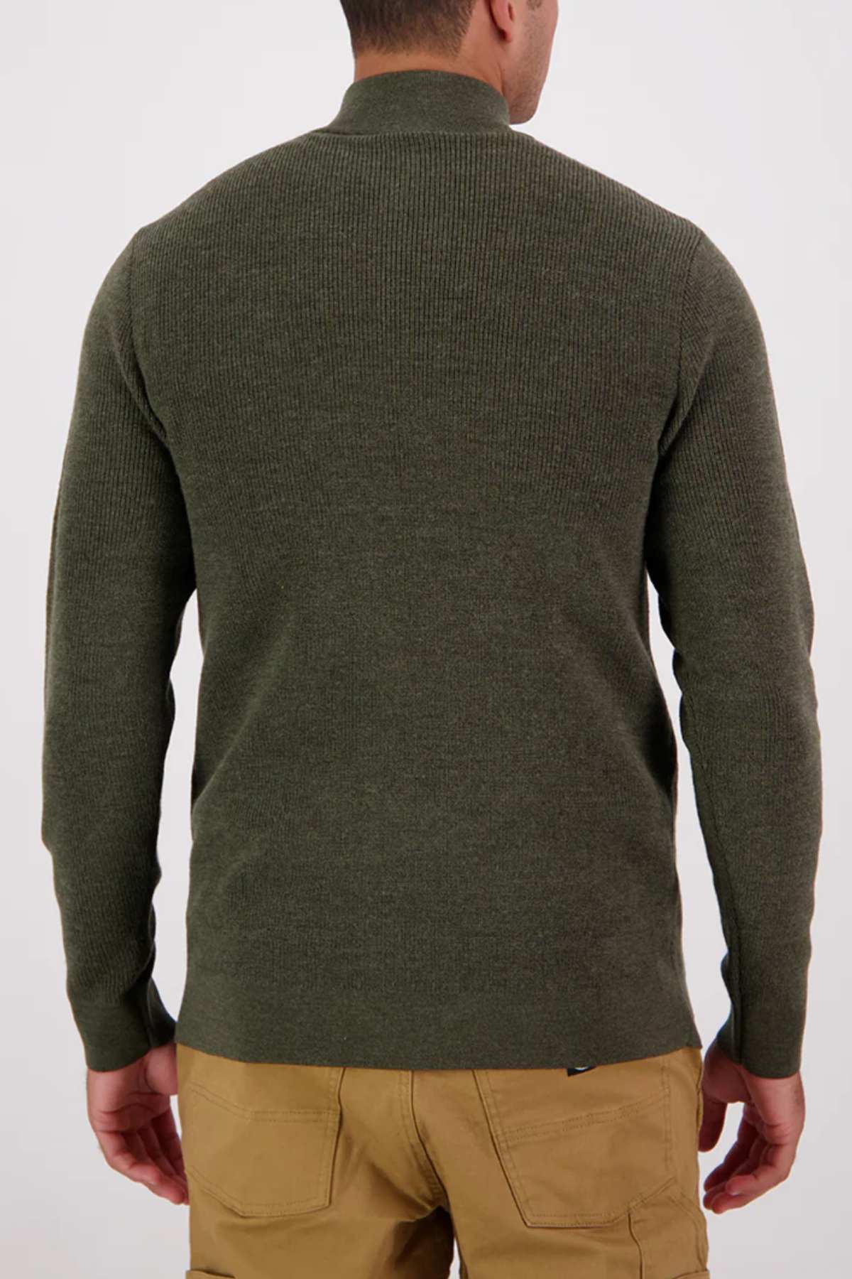 A man stands with his back to the camera, wearing an olive green Swanndri Otahu River Quarter Zip Merino Knit sweater and tan pants against a plain light background.