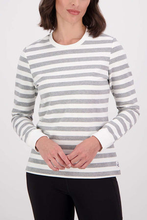 A woman wears the Swanndri Papamoa Stripe Long Sleeve Tee, featuring a relaxed fit for maximum comfort, and black pants while standing against a plain white background with her hands clasped at her waist.