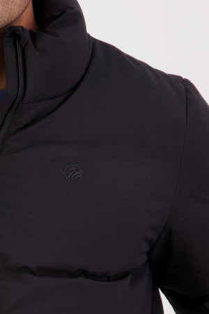 A close-up of the Swanndri Plume Mens Down Jacket, featuring a high collar and subtle chest logo, filled with Duck Down. Shown from the shoulders down against a plain light background—ideal for outdoor activities.