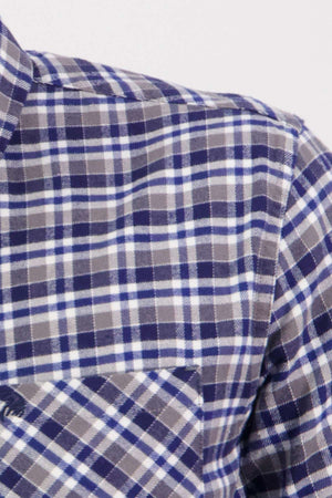 Close-up of the Swanndri Wendon Shirt in blue, white, and gray plaid, featuring a classic fit and front pocket. Made from 100% cotton, this piece showcases a timeless tartan pattern.