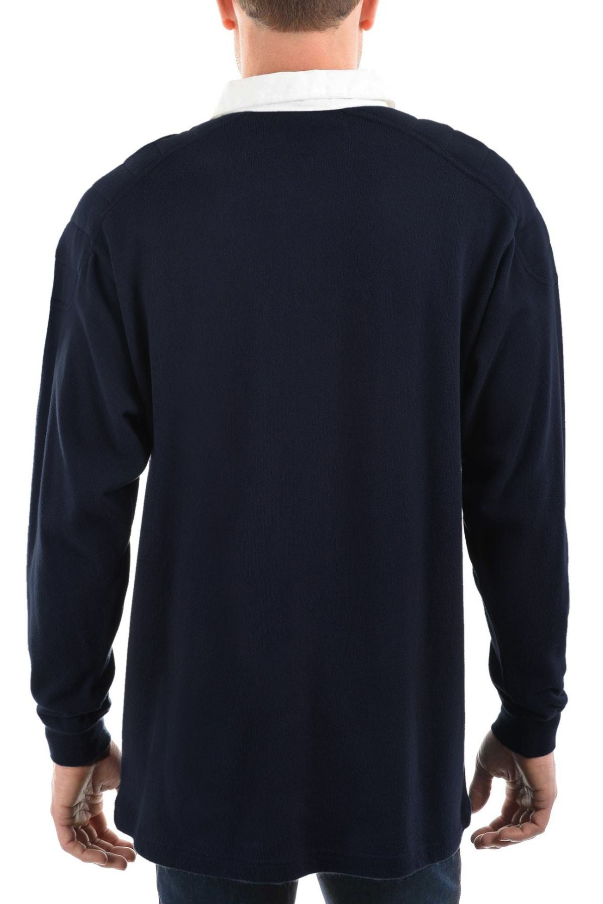 A man wears the Thomas Cook Bill Rugby—a navy blue long-sleeve shirt with a white collar, quilted shoulder panels, and a small embroidered logo—standing against a plain white background.