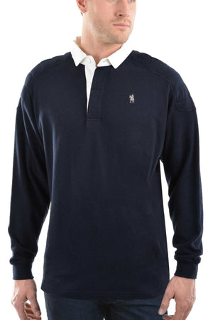 A man wears the Thomas Cook Bill Rugby—a navy blue long-sleeve shirt with a white collar, quilted shoulder panels, and a small embroidered logo—standing against a plain white background.