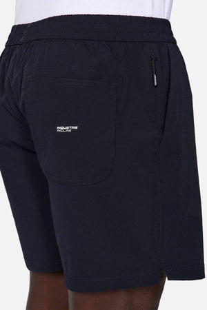 A close-up of a person wearing Industrie The Owens Short—quick drying, above knee shorts with an elasticised waistband, back pocket with a white "Industrie Incline" logo, and a zippered side pocket.