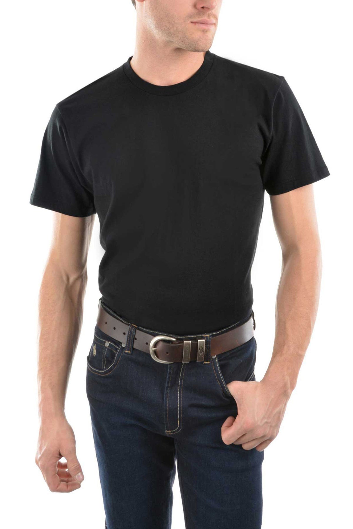A man stands against a white background, wearing the Thomas Cook Classic Fit Tee in plain black (100% combed cotton), dark blue jeans, and a dark brown belt. One hand is in his pocket, the other hangs relaxed by his side.