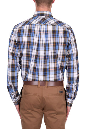 A man is seen from behind wearing the Thomas Cook Daniel Shirt, a blue, brown, and white yarn-dyed check long-sleeve shirt, tucked into tan pants with a brown belt. The background is white.