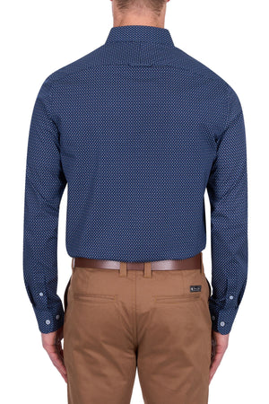 A man is seen from behind wearing the Thomas Cook David Tailored Shirt in navy blue with a geometric print, tucked into tan trousers and paired with a brown belt. His arms are relaxed at his sides, set against a white background.