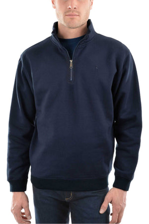 A man in the Thomas Cook Flinders Fleece Top, a navy blue quarter-zip with a stand-up collar, pairs it with dark jeans against a white background—ideal for layering during outdoor adventures.