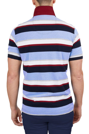 A person photographed from the back wears a short-sleeved Thomas Cook Gavin Polo with multicolour stripes in blue, white, navy, and red. Made from 100% cotton, it’s paired with dark blue pants for a stylish look.
