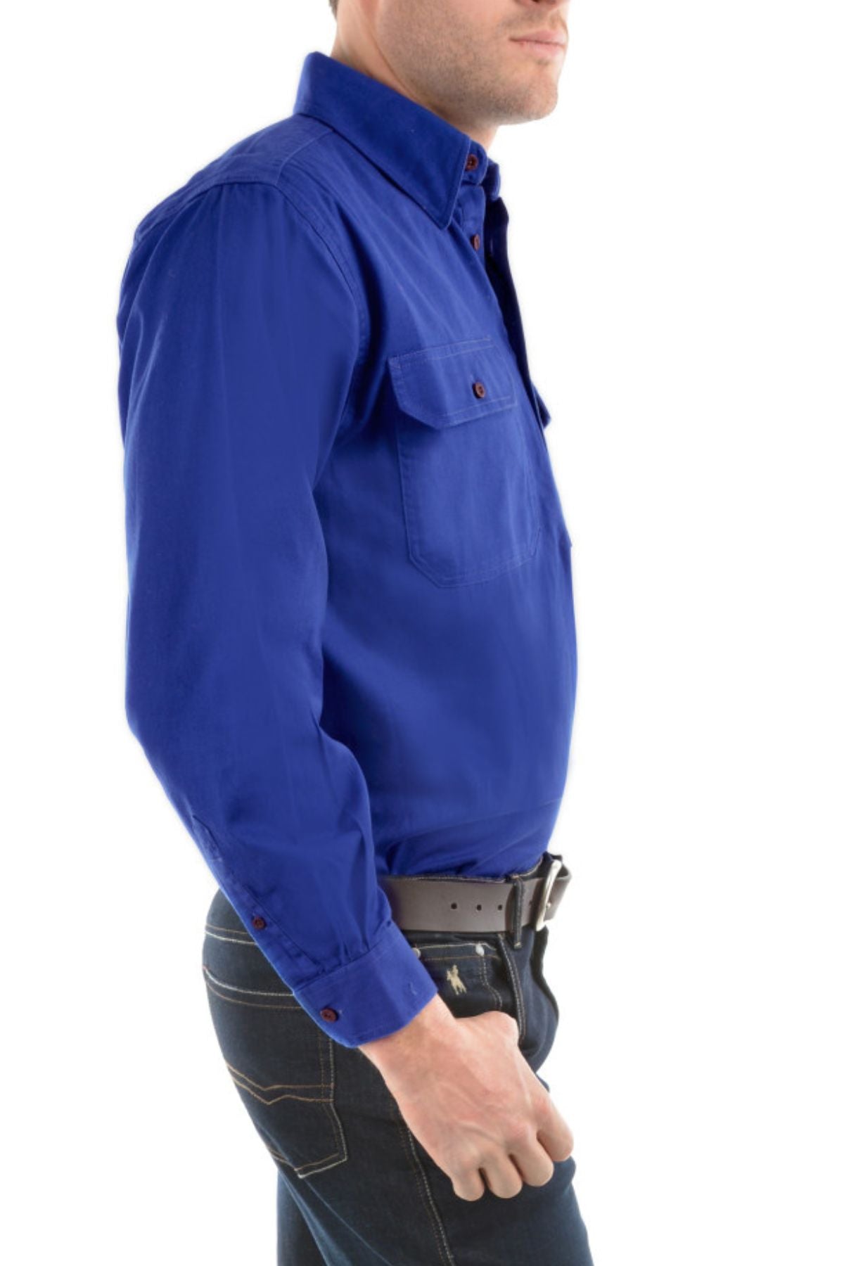 A man in a bright blue Thomas Cook Heavy Drill Half Placket Shirt with chest pockets and dark jeans stands in profile against a white background.