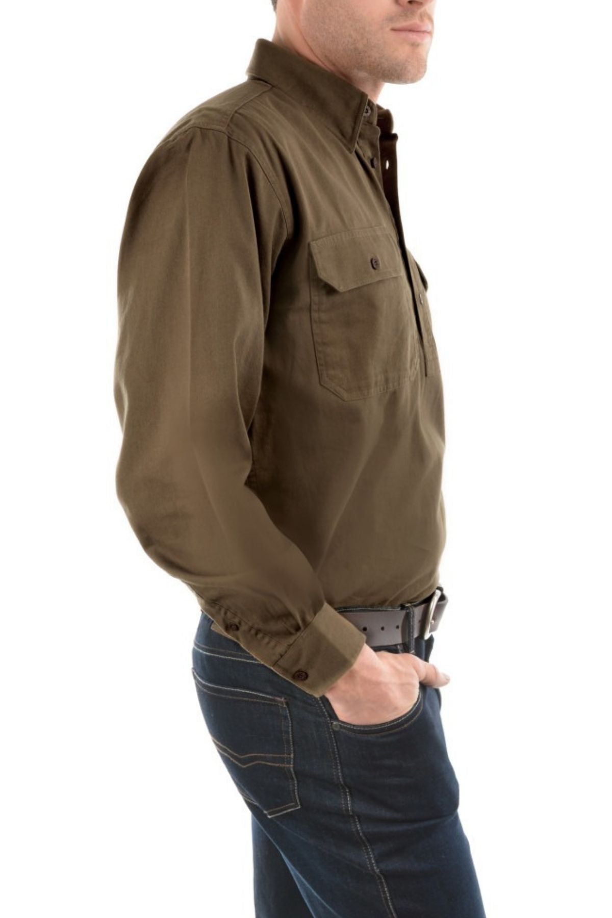 A man in a Thomas Cook Heavy Drill Half Placket Shirt with countryman pockets and dark blue jeans stands sideways with one hand in his pocket against a white background.