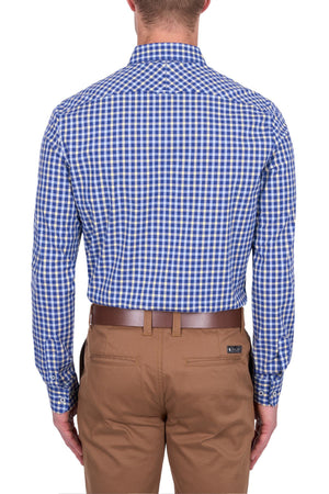 A man is shown from the back wearing the Thomas Cook James Tailored Shirt, a blue and white checkered easy-care dress shirt tucked into tan dress pants with a brown belt.