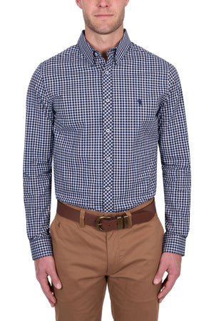 A man wearing the Thomas Cook Jason Tailored Shirt, a blue and white checkered long sleeve, tucked into tan pants with a brown belt, stands against a white background. His head is partially cropped out of the image.