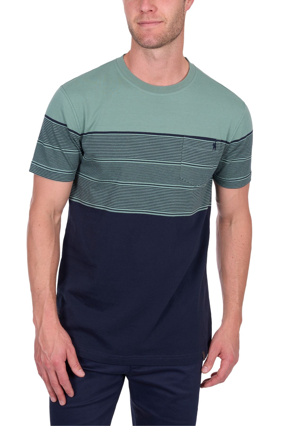 A man stands with one hand by his side, wearing the Thomas Cook Jason Tee: a short-sleeve, 100% cotton crew-neck T-shirt featuring a green top, multi-colour chest stripes, small chest pocket, and solid navy bottom panel.