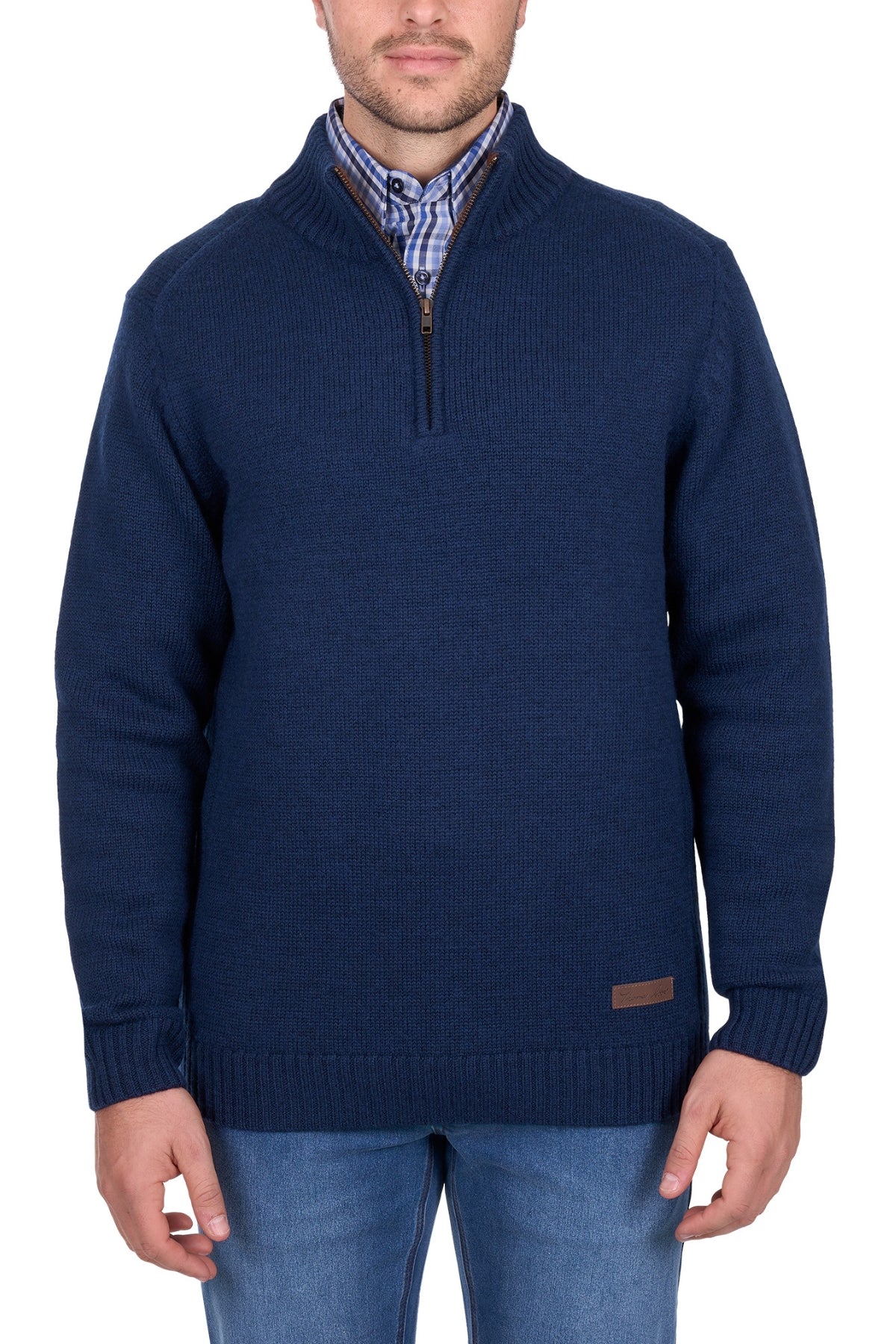 A man wears the Thomas Cook Jesse 1/4 Zip Jumper in navy blue, with a chunky rib knit and half-zip collar, layered over a blue and white plaid shirt and paired with blue jeans, standing against a white background.