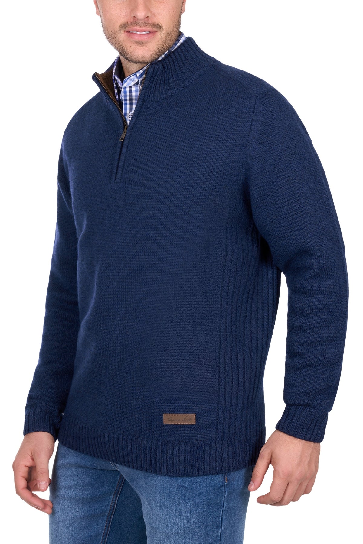 A man wears the Thomas Cook Jesse 1/4 Zip Jumper in dark blue over a checkered shirt and blue jeans, standing with one hand by his side, facing slightly to the left.
