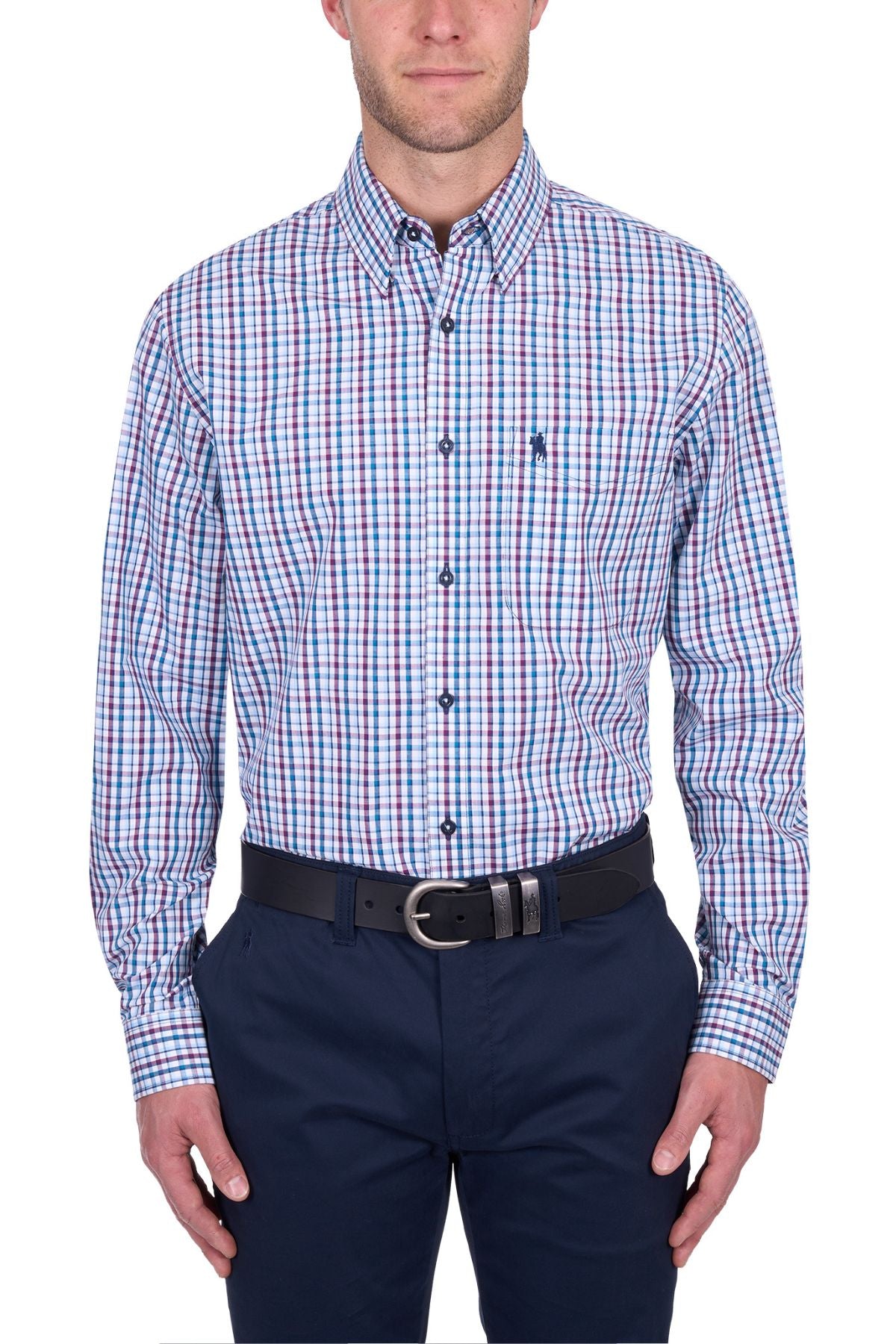 A man wears the Thomas Cook Joseph Shirt, a long-sleeve, blue/red/white plaid 100% cotton button-up, with navy pants and a black belt, standing against a white background.