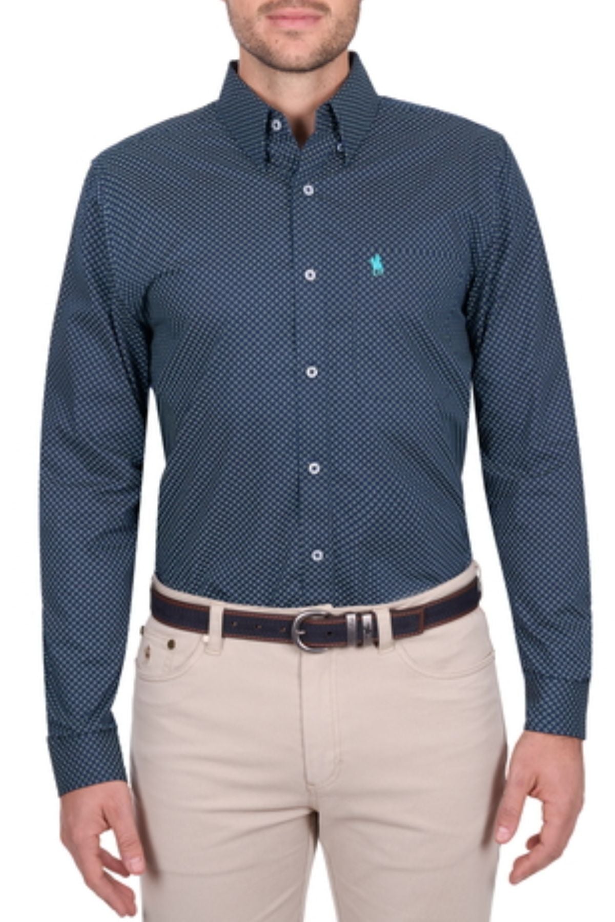 A man stands against a white background wearing the Thomas Cook Kevin Shirt—a dark blue, long sleeve cotton men’s shirt with a subtle geometric pattern—paired with beige pants and a dark belt.