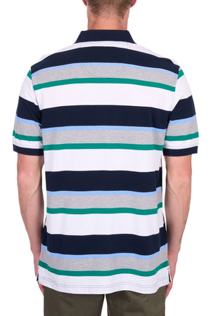 A person is shown from the back wearing a Thomas Cook Paul Polo, a soft cotton pique polo with multi-colour stripes, paired with olive-green pants for a casual yet stylish look.