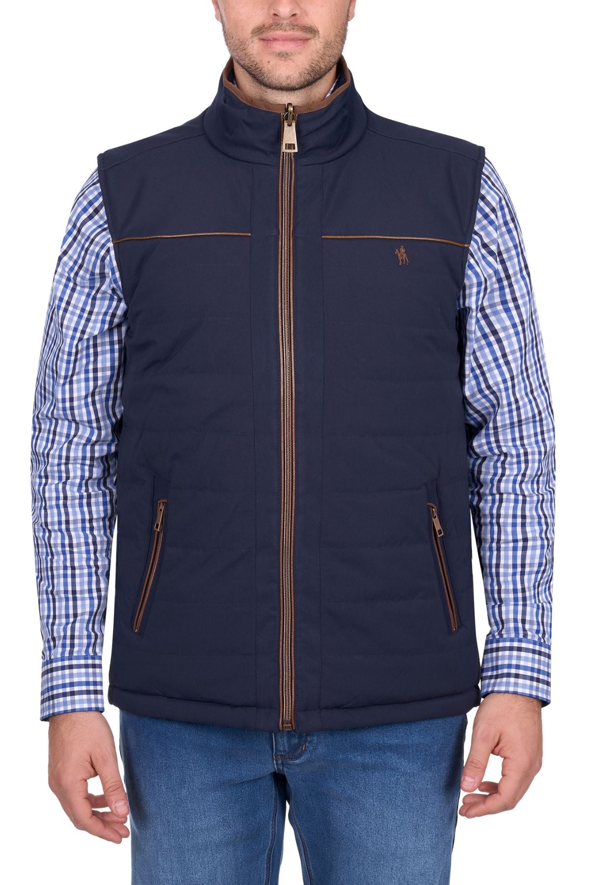 A man wearing the Thomas Cook Toby Revs Vest—a navy blue quilted vest with brown zipper details—over a blue and white checkered shirt and blue jeans, standing facing forward.