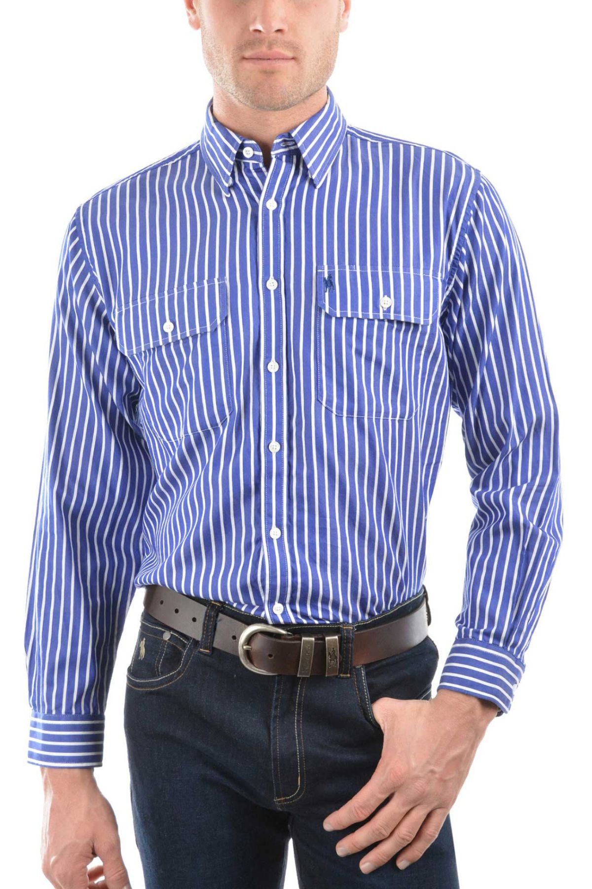 Man wearing the Thomas Cook Winton Shirt, featuring blue and white vertical stripes and double chest pockets, paired with dark jeans and a brown belt, poses with one hand in his pocket against a white background.