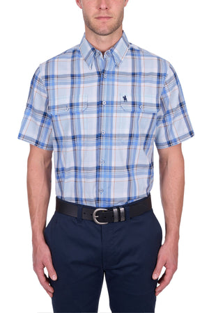 A man wears the Thomas Cook Brian Short Sleeve Shirt—100% cotton, blue and white plaid, button-up with two chest pockets—paired with navy pants and a black belt, against a white background. Ideal for everyday wear.