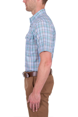 A man in profile wears a Thomas Cook Matt Short Sleeve Shirt in blue and white, tucked into light brown pants with a brown belt, set against a white background.