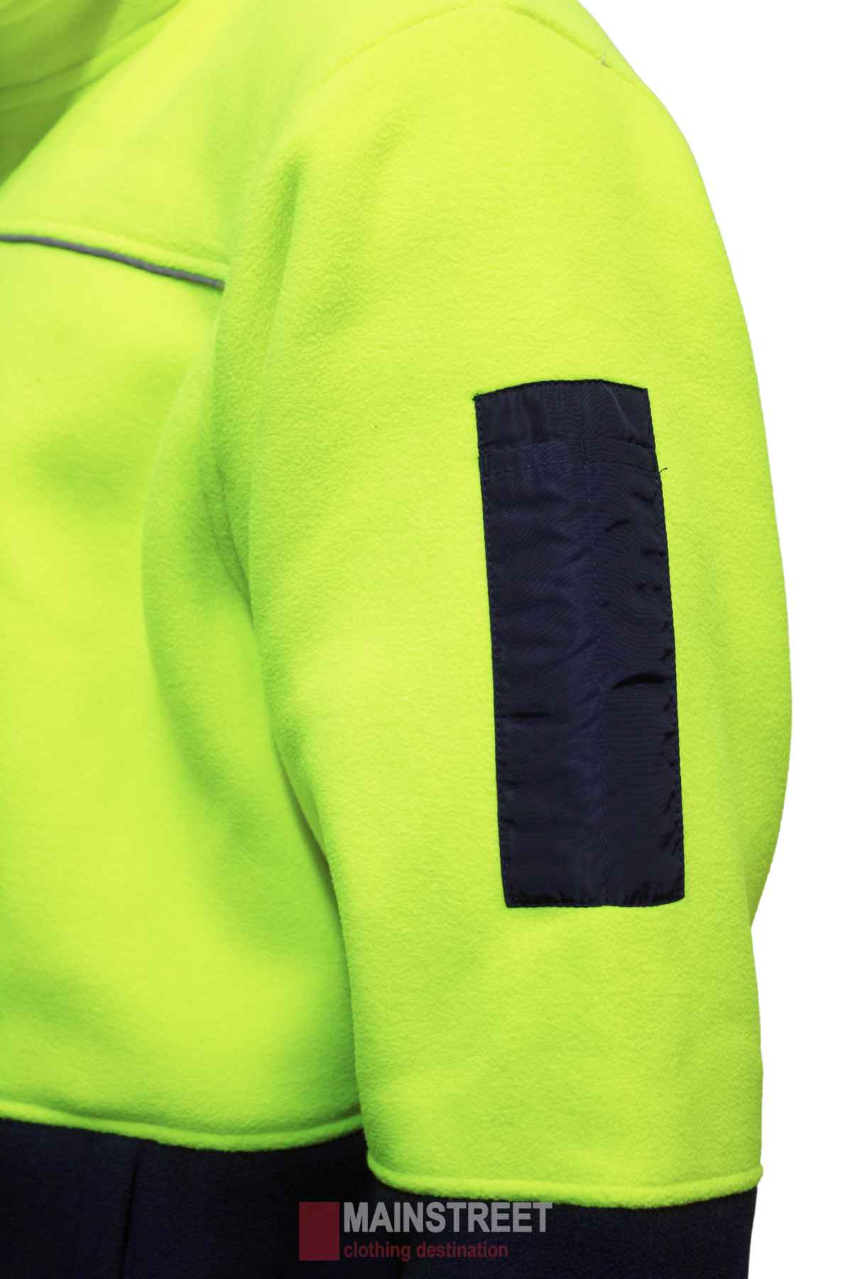 A close-up of a MakRear Sherpa Polar Fleece Jacket sleeve in bright yellow-green with a black patch. This full zip jacket has a cozy Sherpa lining and the faint "MAINSTREET clothing destination" logo at the hem.