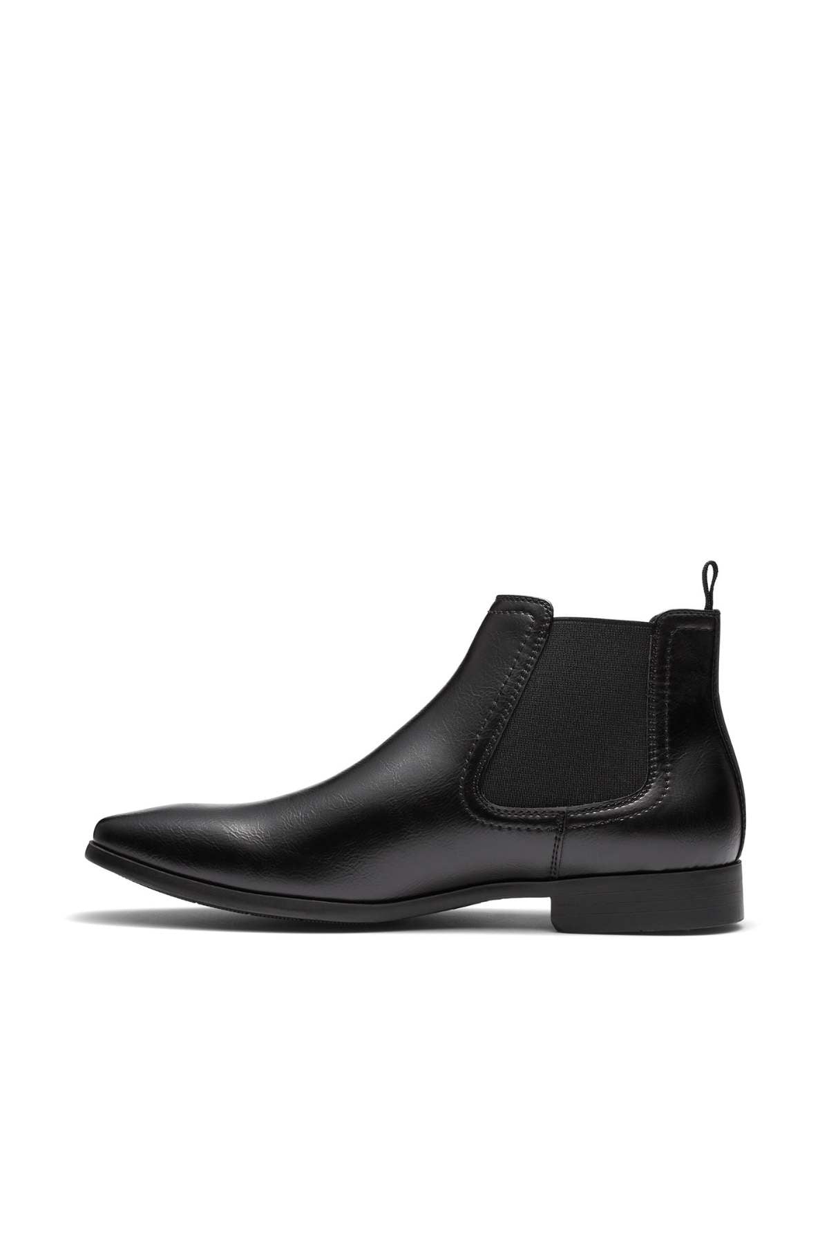 A side view of the UNcut Newlands Boot, a black leather Chelsea boot, showcasing an almond toe shape and elastic gusset with a low heel against a white background. This versatile boot is perfect for any occasion and available in UK sizing.