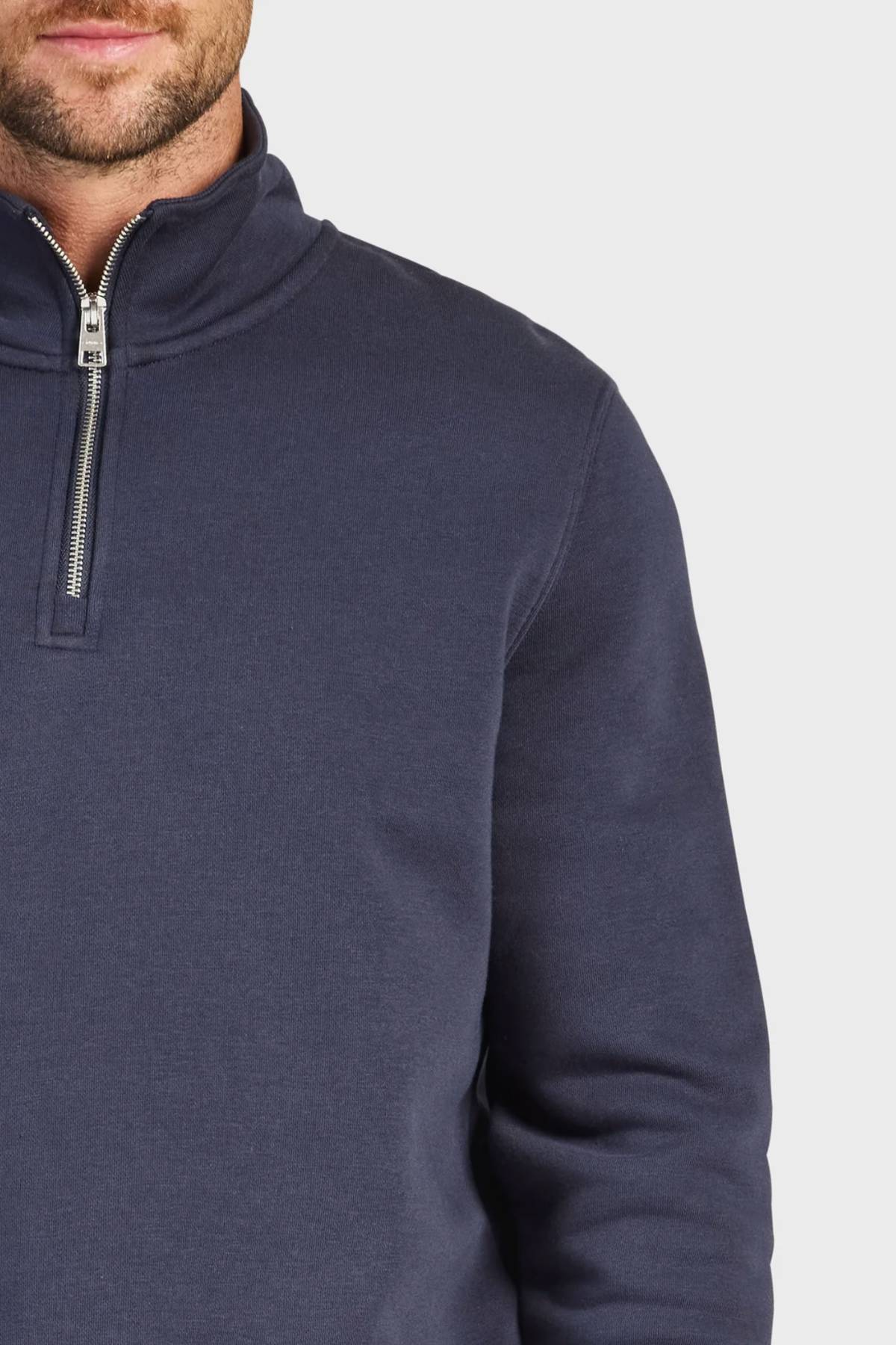 Model wears the Academy Brand 1/4 Zip Sweat in navy, cut from premium brushed fleece. Only the lower face, neck, and upper torso are shown against a light gray background.