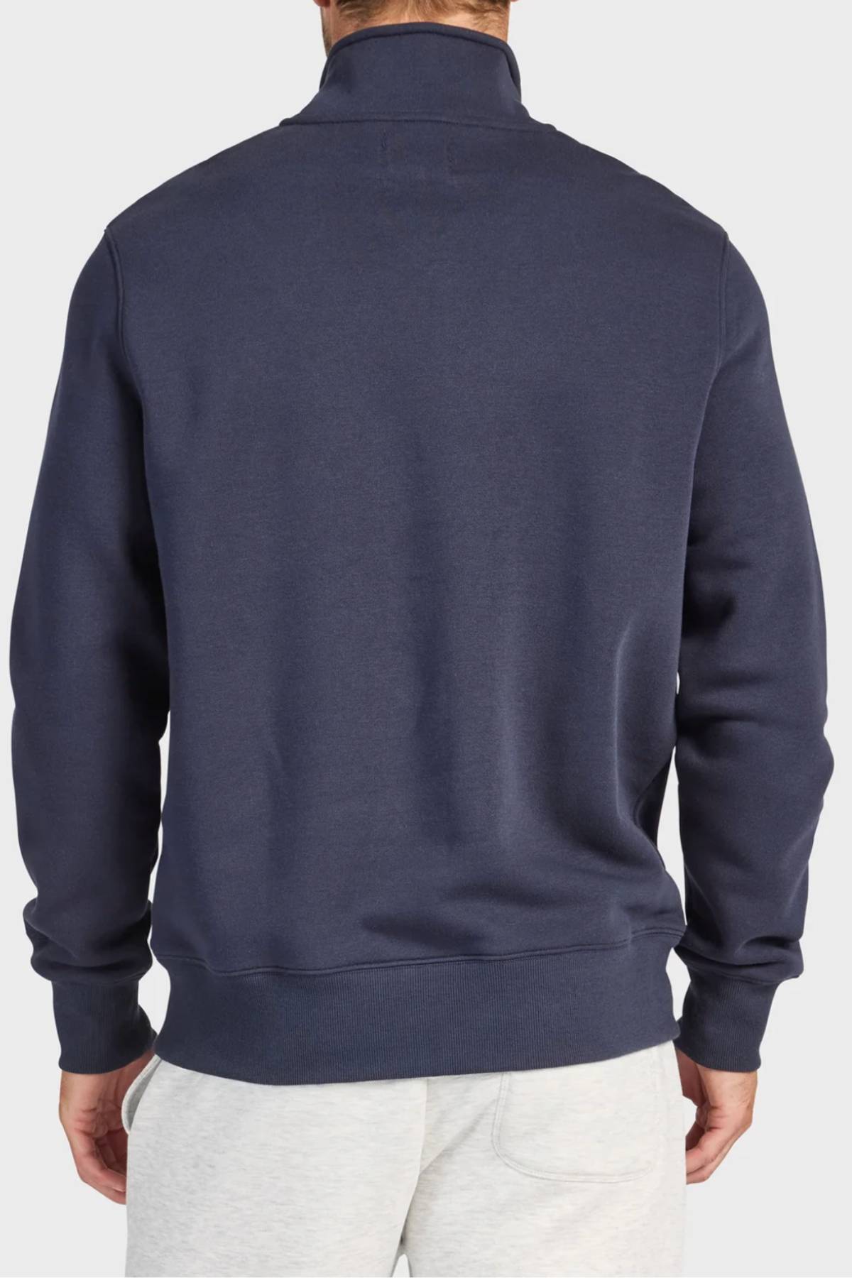 A man is shown from the back wearing the Academy Brand 1/4 Zip Sweat in premium brushed fleece with light gray pants, standing against a plain light background.