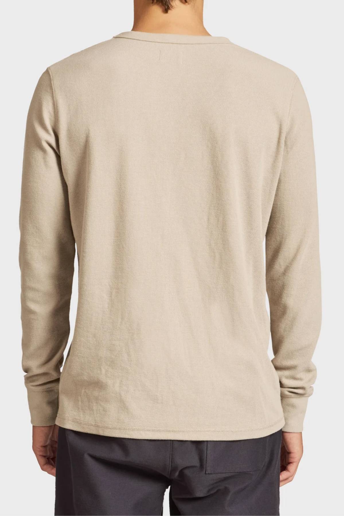 A person is shown from the back wearing the Academy Brand Workers Crew, a durable light beige long-sleeve shirt with dark pants. Its plain French rib design offers a clean, classic look with no visible logos or patterns.