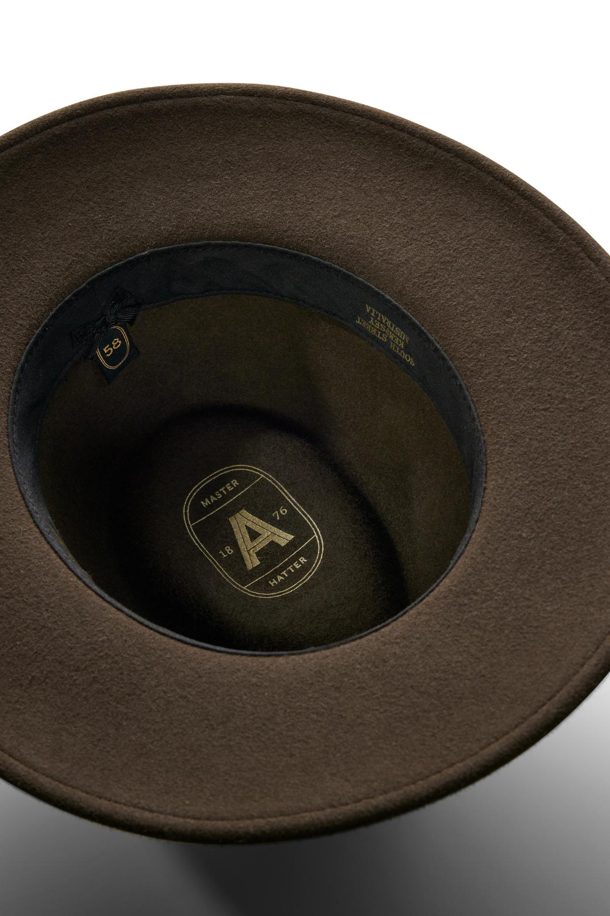 Close-up view of the inside of the Akubra Traveller hat, featuring a brown felt finish, black inner band, and gold-printed logo and details on the crown—ideal for those seeking style and comfort.
