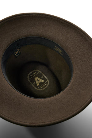 Close-up view of the inside of the Akubra Traveller hat, featuring a brown felt finish, black inner band, and gold-printed logo and details on the crown—ideal for those seeking style and comfort.