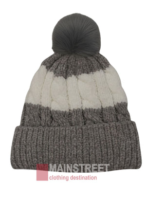 The Anticorp Ladies Snowbunny Lined Beanie features a gray and white color block design, thick ribbed cuff, cable knit texture, cozy fleece lining, and a large gray pom-pom. "MAINSTREET clothing destination" logo is overlaid at the bottom.