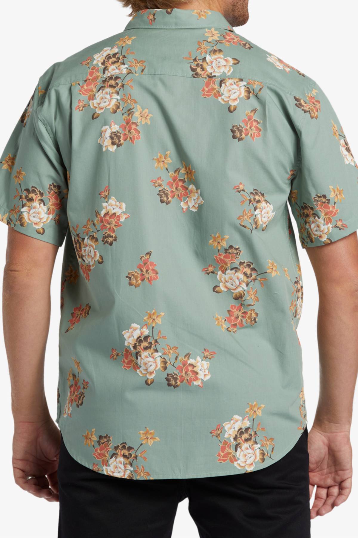 A person wears the Billabong Sundays Mini Short Sleeve Shirt, a light green short-sleeve shirt featuring a bold seasonal print in white, orange, and brown; the photo shows their back and part of their arms.