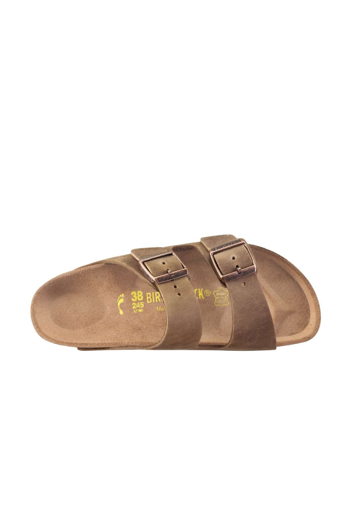 The Birkenstock Arizona is a brown sandal featuring two adjustable straps with metal buckles, an open toe design, and a flat footbed. The inner sole is marked with yellow text and brand logos.