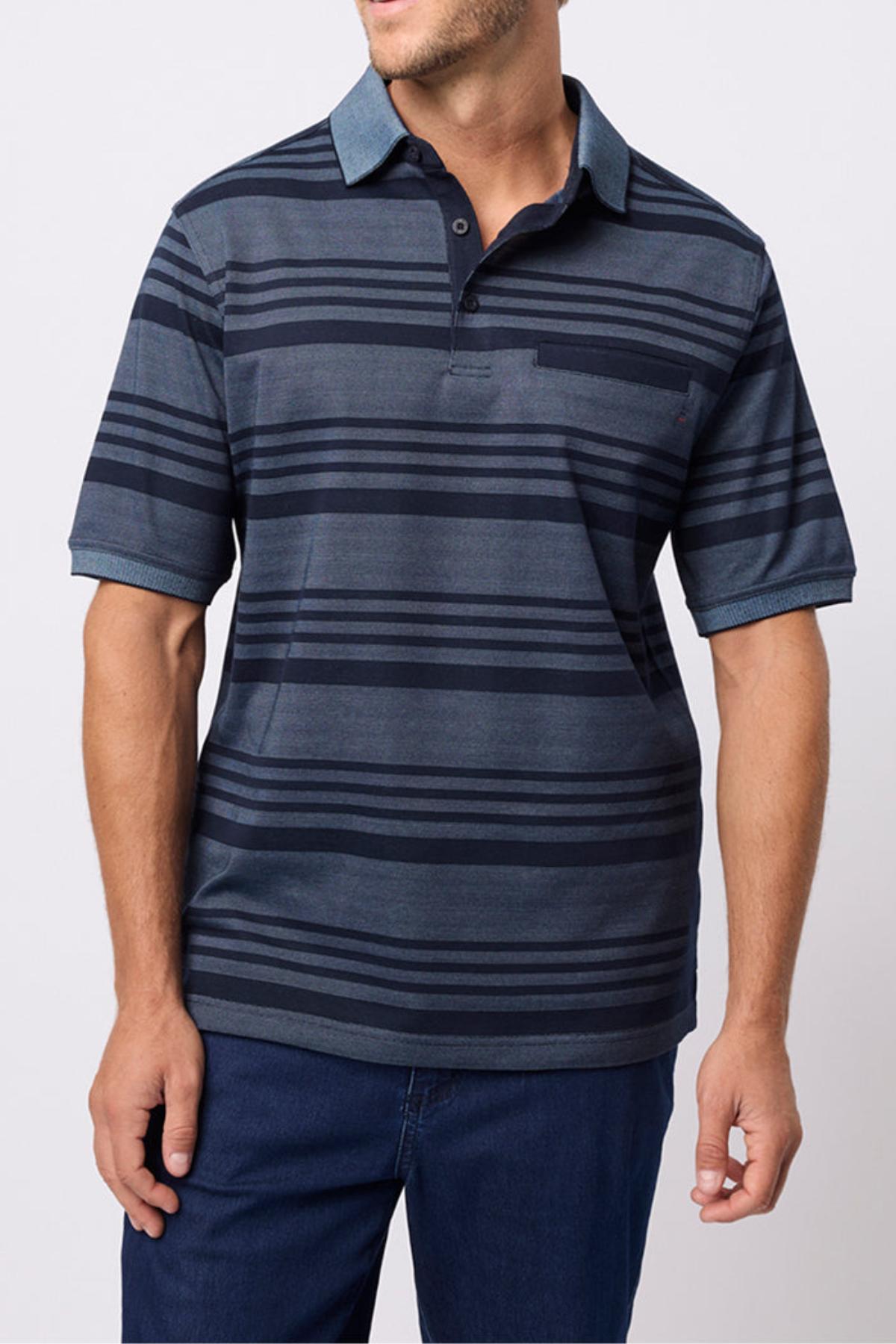 A man wearing the Breakaway Ryle Micro Prima Polo in dark blue with horizontal stripes and navy blue pants stands against a plain light background, his face partially out of frame.