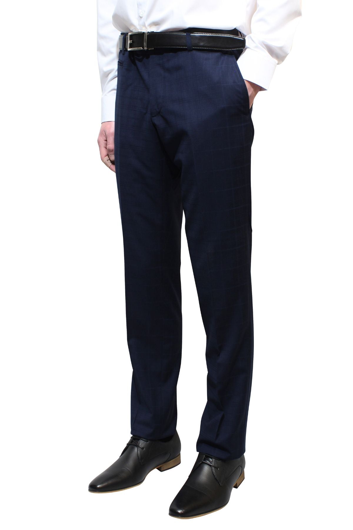 A person wearing navy blue Bruton Jesse Check Trouser pants with a black belt and black dress shoes. The individual is also wearing a white dress shirt with their hands in their pockets. The background is plain white.