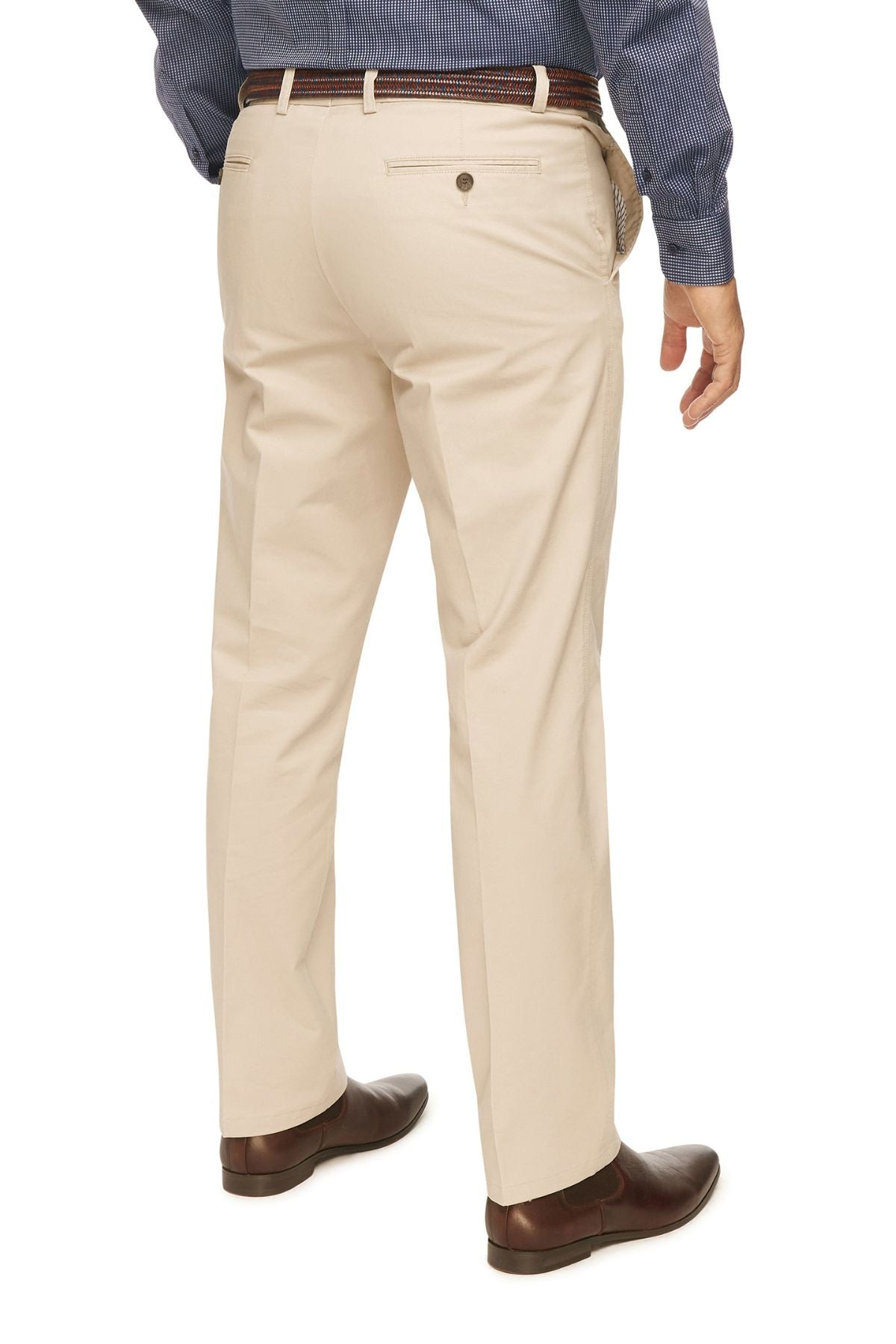 A person is shown from the back, wearing City Club Mariner Harbour Pant in beige, featuring elasticated sides. They are paired with a brown belt, dark brown dress shoes, and a blue long-sleeve shirt. The background is plain white.