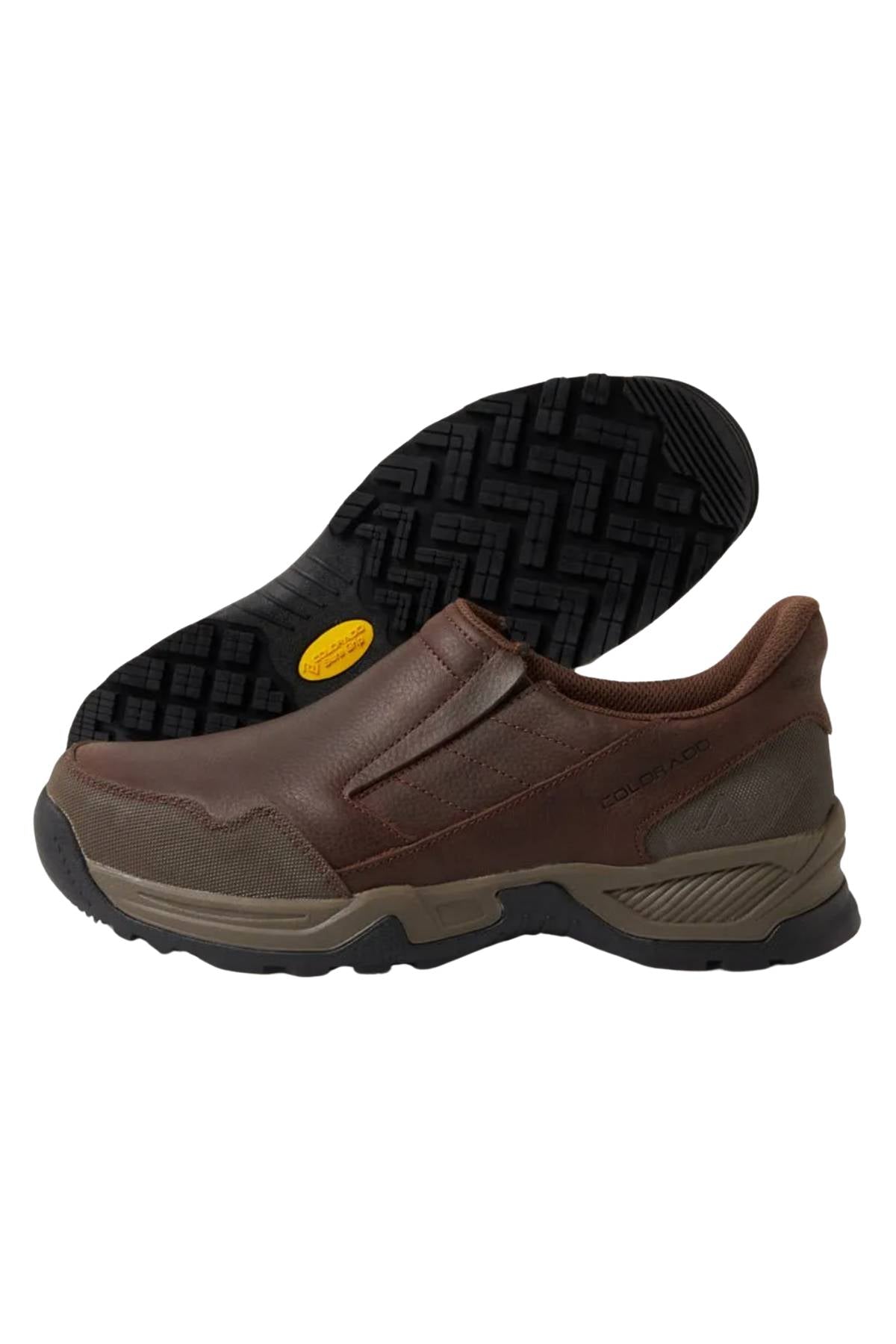 The Colorado Joao Casual Shoe is a brown slip-on with a textured black Sure Grip Outsole, displayed with one shoe upright and the other on its side to show the sole tread pattern.
