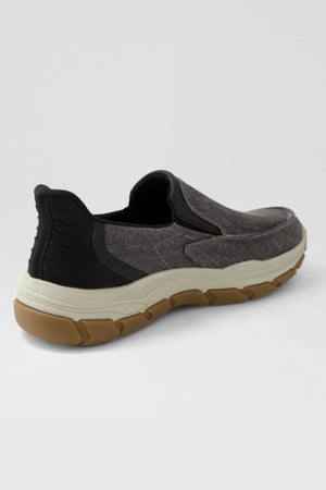 The Colorado Kanza Canvas Shoe is a casual, hands-free slip-on with a dark gray upper, black heel accents, white midsole, and brown slip-resistant rubber outsole, shown on a light gray background.