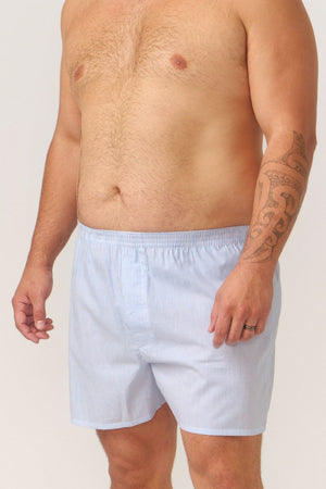 A man stands shirtless against a plain background, wearing Contare Cotton 2 Pack Check Boxer Shorts, revealing a tattoo on his right arm and a wedding ring on his left hand.