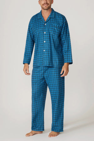 A man stands barefoot against a plain light background, wearing the Contare Country Winter Flannelette PJ Set in blue with long sleeves, button-up front, and a small geometric pattern.