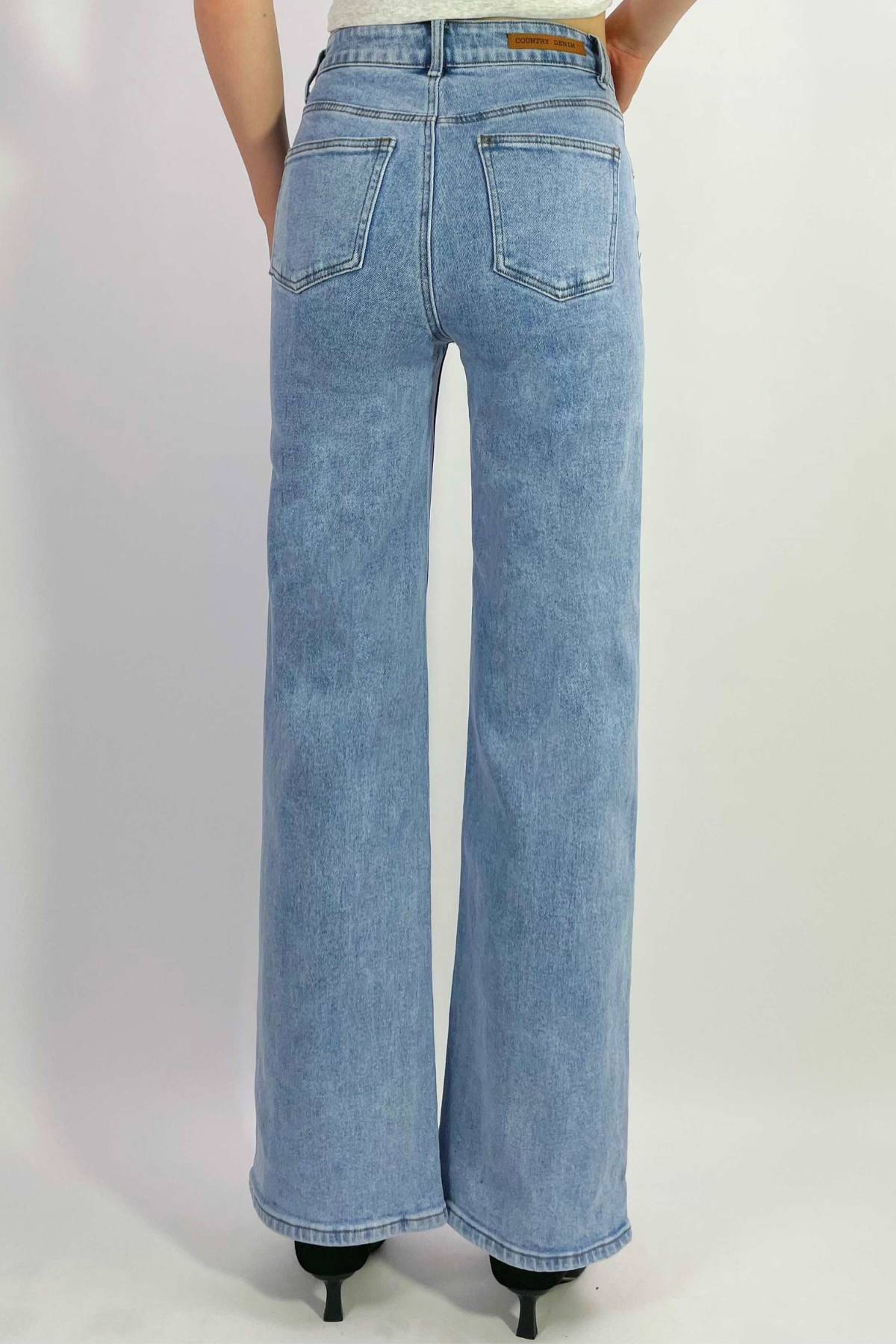 A person is shown from the back against a plain white background wearing light blue Country Denim Straight Leg Stretchy Jeans and black pointed-toe shoes.