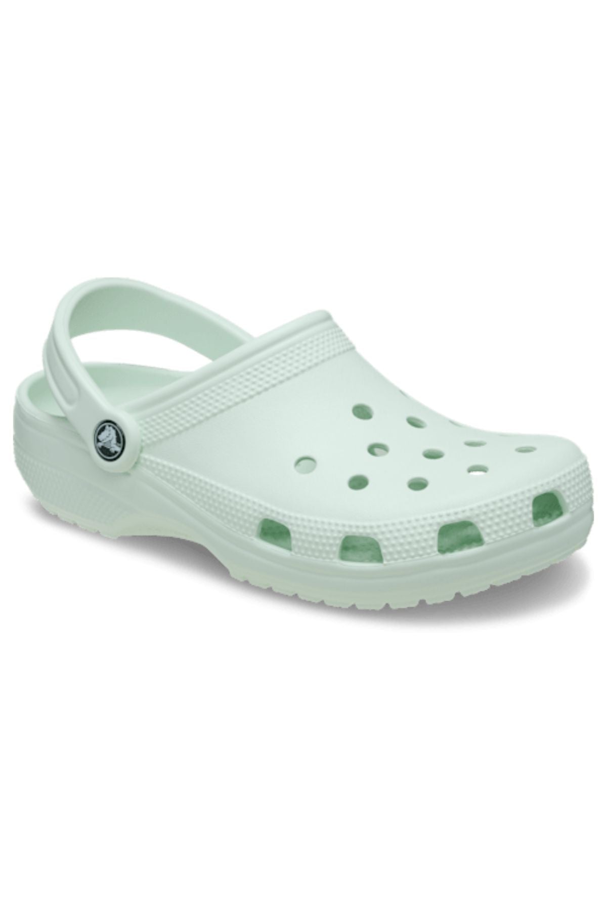 The Crocs Classic Clog in light green features ventilation holes on the top and sides, a textured sole, an adjustable heel strap, and a small circular logo near the ankle for added style. Lightweight and breathable for all-day comfort.