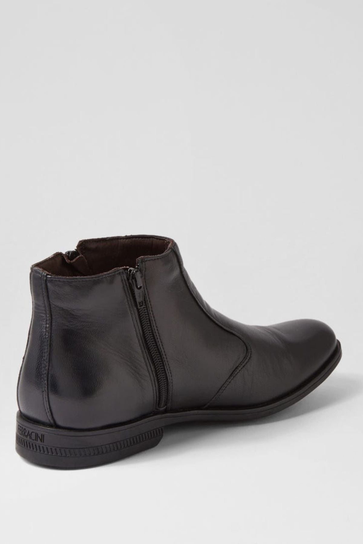 The Ferracini March Boot, crafted in black genuine leather with a side zipper, low heel, and round toe, is the perfect men's zip boot—shown against a plain light gray background.