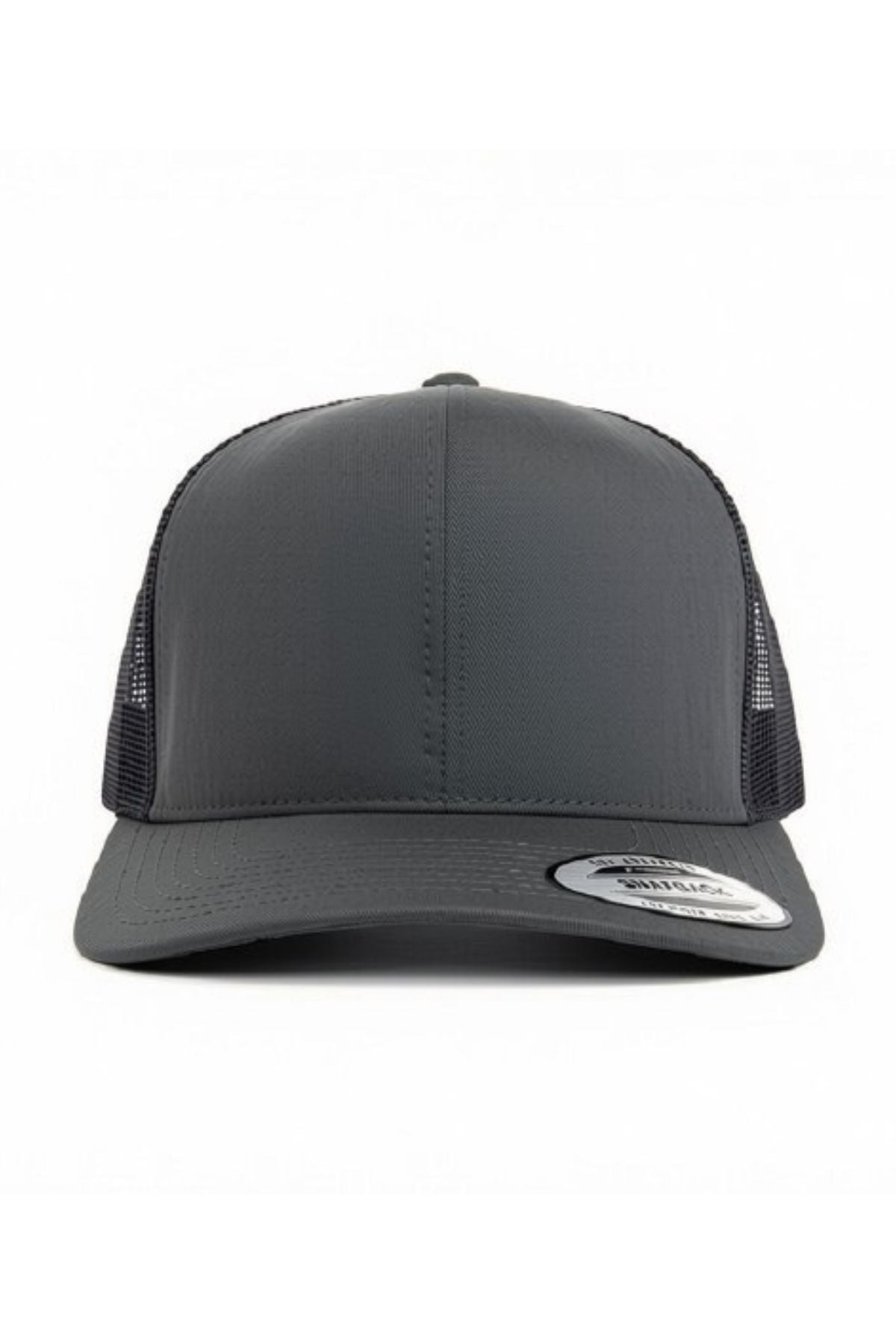A front view of the FlexFit Trucker Cap in dark gray showcases its mesh back and curved brim. The adjustable snapback provides a comfortable fit, and a silver sticker is visible on the brim. The cap is set against a plain white background.