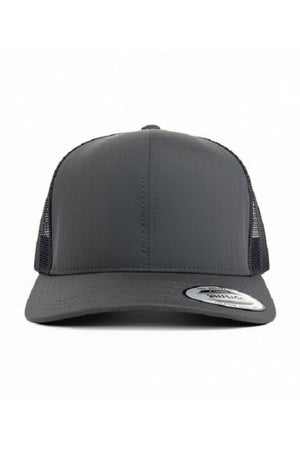 A front view of the FlexFit Trucker Cap in dark gray showcases its mesh back and curved brim. The adjustable snapback provides a comfortable fit, and a silver sticker is visible on the brim. The cap is set against a plain white background.