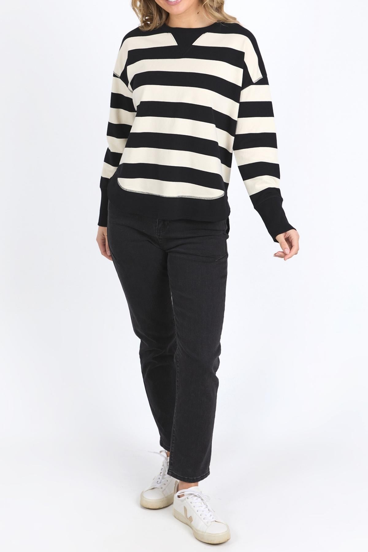 A person wearing a Foxwood Delilah Stripe Crew, black pants, and white sneakers stands against a plain white background.