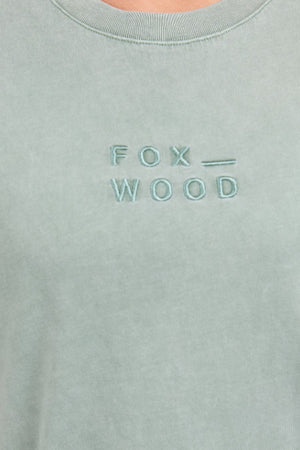 Close-up of the Foxwood Huntleigh Oversized Tee in light green, relaxed fit, featuring "FOX _ WOOD" embroidered in capitals on the chest.
